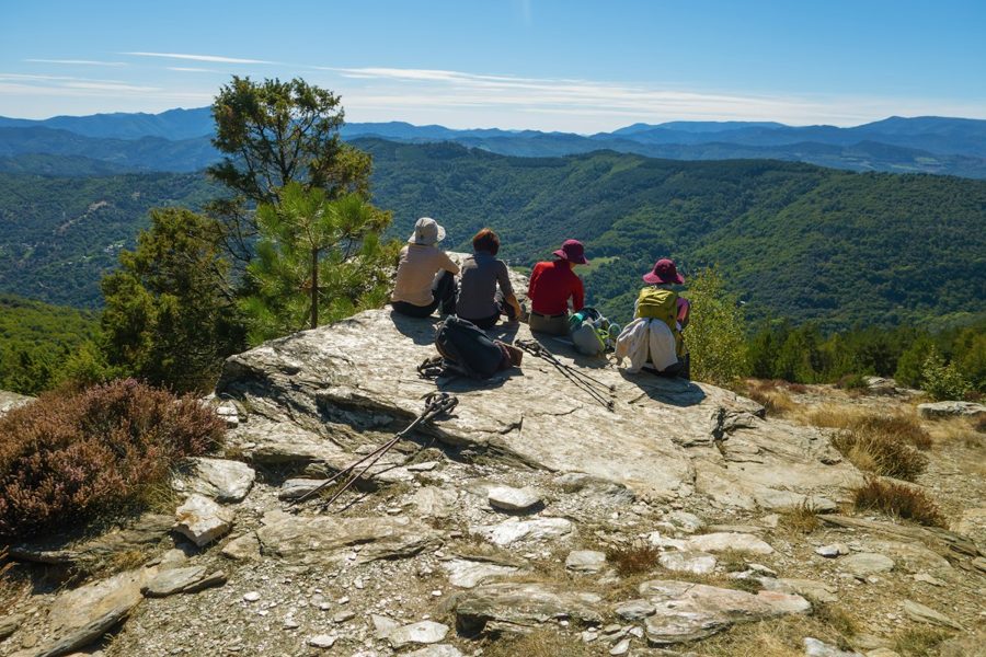 Four hikers resting on a mountain top